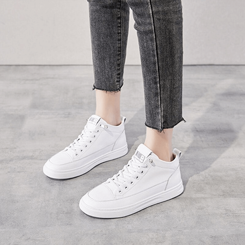 Woman wearing Sports Lace-Up Genuine Leather Vulcanized Shoes in white, demonstrating style and comfort for all-day wearability.